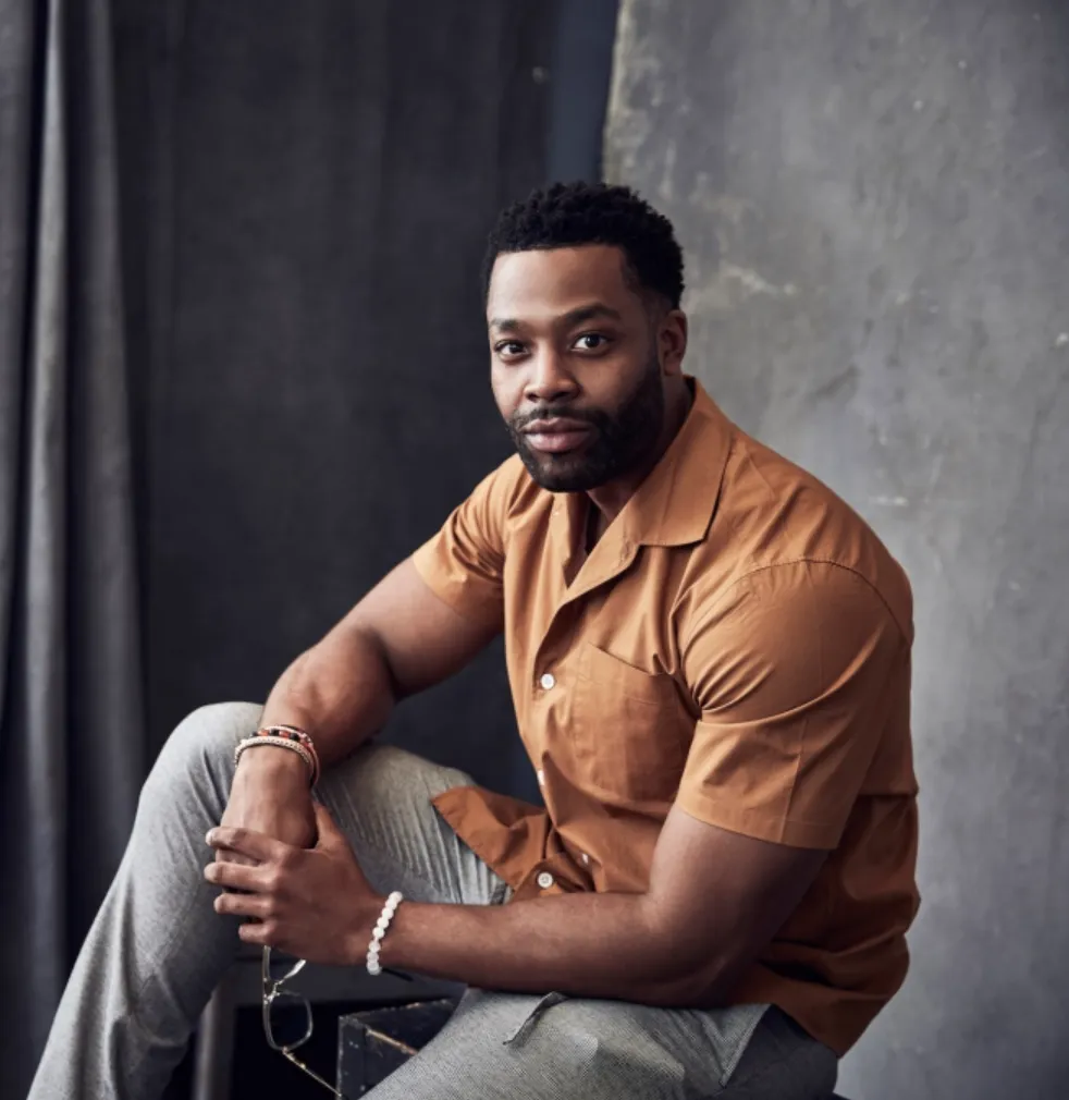LaRoyce seated in a rust-colored short-sleeve shirt